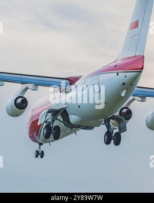 Balikpapan, Indonesia - September 26th, 2024. The Indonesian presidential jet with its landing gear extended and flaps deployed. The plane has red and Stock Photo