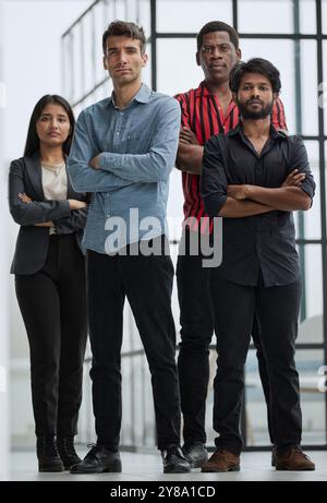 Friends smiling and standing together in office Stock Photo