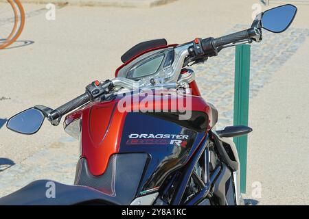 Close up of the dashboard and handlebars of a red and black dragster 800 rr motorcycle parked outdoors on a sunny day Stock Photo