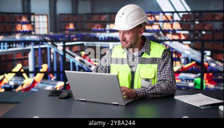 Man Staff In Parcel Delivery Center Using Computer Stock Photo