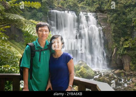 Couple posing for photos in front of Marokopa Falls. Waikato. New Zealand. Stock Photo