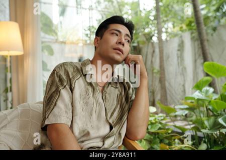 Pensive Man Looking Through The Window Stock Photo
