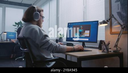 Adult man in headphones enters prompt in artificial intelligence chatbot on personal computer. AI video generator app generate detailed video of dancing ballerina. Advanced AI generated video creation Stock Photo