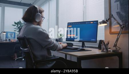 Adult man in headphones types prompt in AI video generator on PC. Artificial intelligence chatbot generate detailed high-quality dancing ballerina video. From text prompt to realistic generated video. Stock Photo