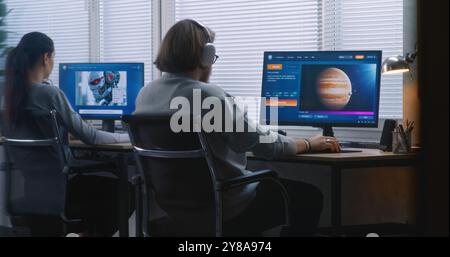 Two diverse workers using AI generator on computers in office. PC screens showing artificial intelligence chatbot generating text prompt to realistic images or videos. AI generated content. Back view. Stock Photo