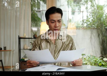 Man Examining Documents At Home Stock Photo