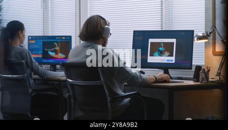 Back view of team of workers using AI generator on computers in office. PC screens showing artificial intelligence chatbot generating text prompt to realistic photo or video content. Automated artwork Stock Photo