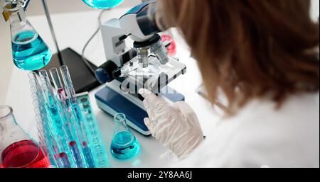 Older Female Scientist In Lab With Microscope Stock Photo