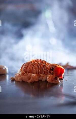 Lobster tail cooking on smokey teppan grill Stock Photo - Alamy