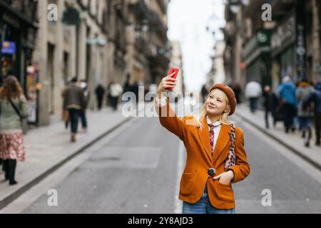 Young woman taking selfie walking down the street in barcelona Stock Photo