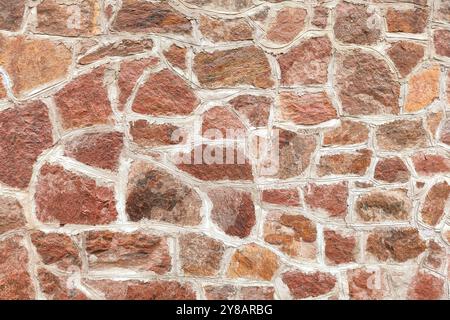 Texture of red granite wall. Texture and background of the stone. Acient granite wall. Grunge brick wall background. Background of old vintage brick w Stock Photo
