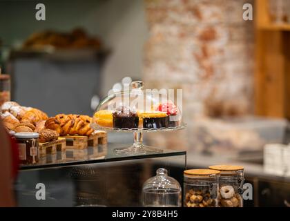 Display of baked goods in the cafe.  Various sweets and desserts in the coffee shop display close up. Stock Photo