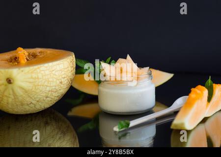 sweet homemade yogurt in a jar with pieces of ripe melon . Stock Photo