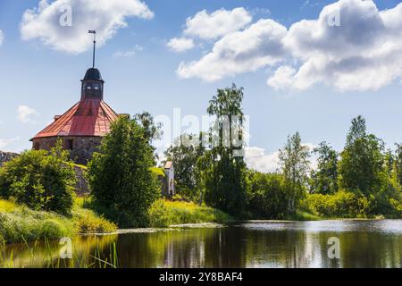 Summer landscape with Korela Fortress at the lake coast on a sunny summer day. This a medieval fortress is located in the town of Priozersk, Russia Stock Photo