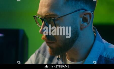 Concentrated Caucasian crypto trader man male late night work touching keys keyboard computer freelancer boy worker looking monitor writing statistics Stock Photo