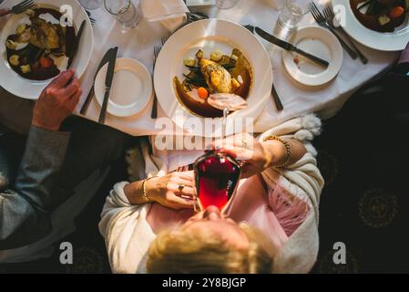 Overhead view in a senior woman drinking glass of red wine Stock Photo