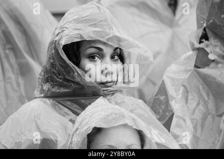 HOODS UP, SUMMER STORM, BEACH VOLLEYBALL, MARIEHAMN, 2011: It's hoods up for the Brazil fans when the rain gets really heavy. The crowd cover up with disposable rain ponchos as a huge summer storm sweeps through the stadium with a deluge of rain during the semi-finals in August 2011 at the Paf Open in Mariehamn, Åland, Finland. Photograph: Rob Watkins.   INFO: Between 2009-2013 the PAF Open Beach Volleyball tournament was an annual event held in Mariehamn, Åland, Finland. It attracted the top international teams and players as a ranking part of the official FIVB World Tour, showcasing high-lev Stock Photo