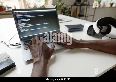 Unrecognizable male hands typing on keyboard, eclectic devices on top of work desk Stock Photo