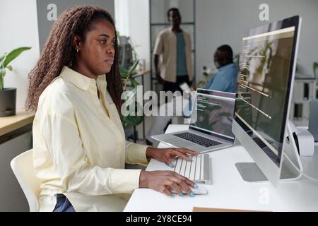 African American woman focused on programming, she writing codes Stock Photo