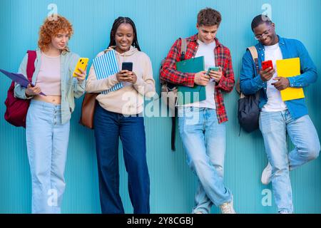 Four students having fun with mobile phones creating content on social media. Stock Photo