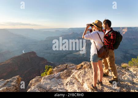Portrait of happy young couple having fun on their hiking trip. Caucasian and asian hiker couple enjoying themselves on summer vacation. They are watc Stock Photo