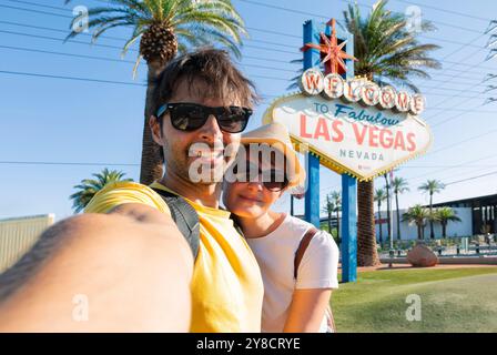 Happy young couple of tourists take selfie near Las Vegas Welcome sign. Two exited students take self portrait -  Nevada, USA Stock Photo