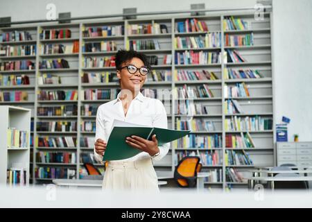 An enthusiastic teacher inspires students while standing confidently in a bright library. Stock Photo