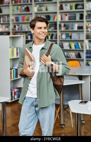 A focused student carries books and smiles while navigating his library environment. Stock Photo