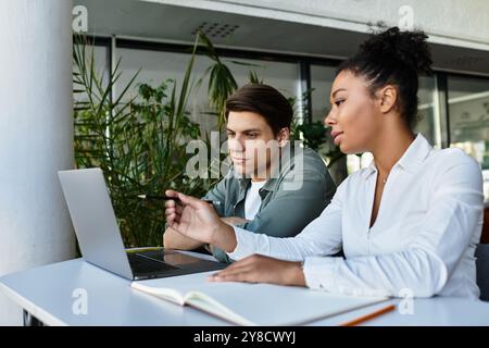 Student and his teacher  collaborating at a study table in a vibrant library environment. Stock Photo