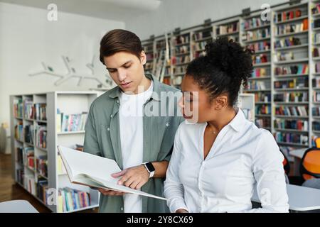 A passionate educator shares knowledge with her attentive student in a cozy library. Stock Photo