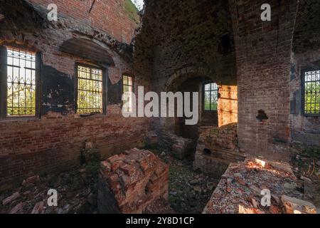 Brick ruins of an abandoned church with iron bars on the windows Stock Photo