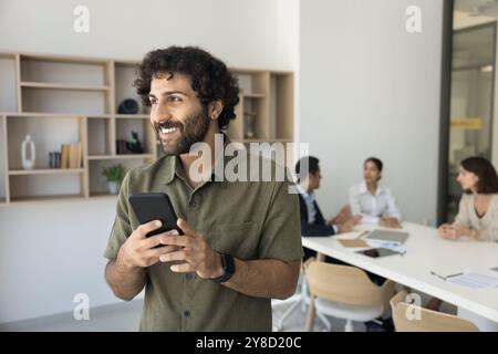 Young Arabian guy take break in work enjoy using smartphone Stock Photo