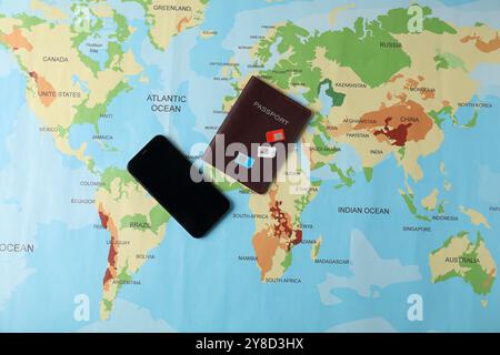 SIM cards, smartphone and passport on world map, flat lay Stock Photo