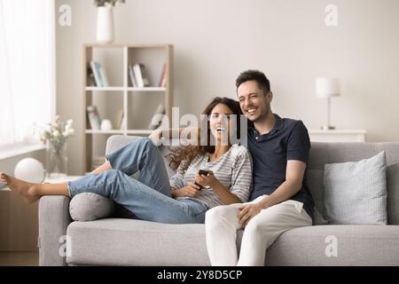 Joyful excited pretty couple spending leisure time at TV Stock Photo