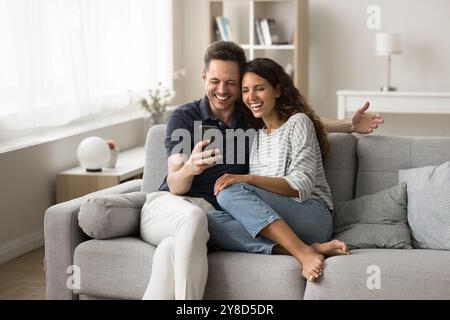 Cheerful married couple using application on mobile phone Stock Photo