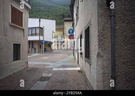 Narrow street bordered by houses in a town in the mountains on a cloudy day Stock Photo