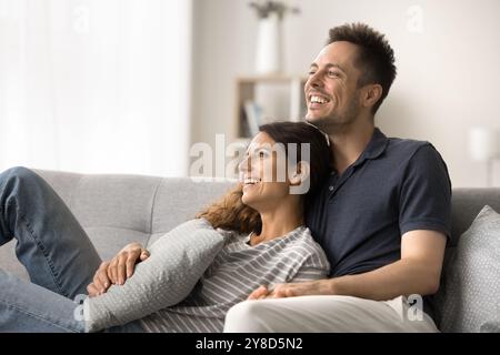 Dreamy cheerful young married couple resting on couch Stock Photo