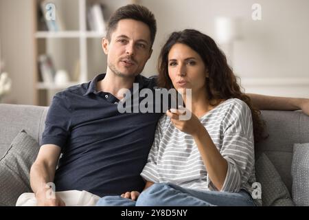 Serious attractive young husband and wife engaged in movie, series Stock Photo