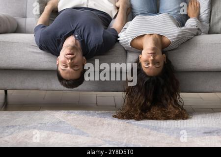 Sleeping young married couple lying upside down on home sofa Stock Photo