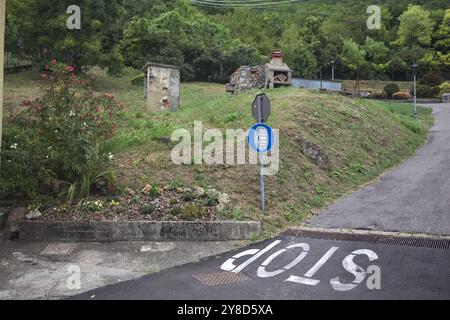 Stop sign on a descending road in the mountain Stock Photo