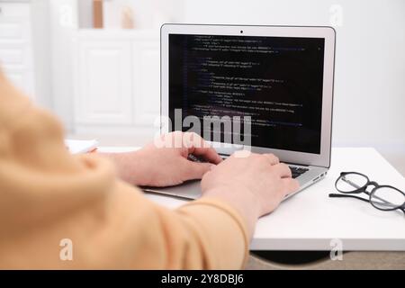 Programmer working with laptop at desk in office, closeup Stock Photo