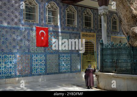 Istanbul, Turkey - September 23, 2024: A woman visiting the Eyup Sultan Mosque and the mausoleum of Abu Ayyub al-Ansari in Istanbul, Turkey. Stock Photo