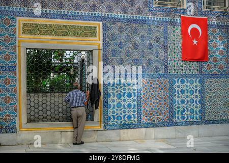 Istanbul, Turkey - September 23, 2024: A man visiting the Eyup Sultan Mosque and the mausoleum of Abu Ayyub al-Ansari in Istanbul, Turkey. Stock Photo