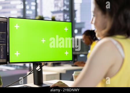Worker conducting code review on green screen computer to fix bugs, identifying performance and technical issues with artificial intelligence company software. Woman optimizing code mockup PC Stock Photo