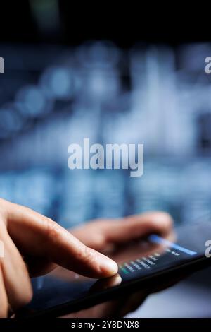 Close up of certified system administrator updating server rigs, writing intricate binary code scripts on tablet. Computer scientist using programming to fortify cybersecurity in high tech place Stock Photo