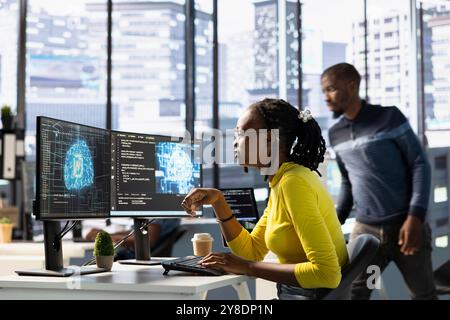 Computer scientist conducting experiments and tests to optimize machine learning models for performance and accuracy. African american IT expert in office analyzing and interpreting complex AI data Stock Photo