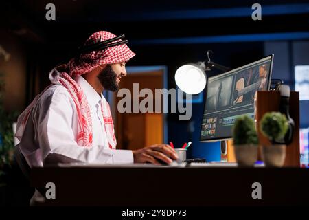 Male cinematographer editing new project, creating film montage, and working with footage and sound. Detailed shot shows a man using post-production software to process a movie on a computer. Stock Photo