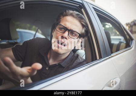 Accident. Young caucasian man driving a car shocked about to have traffic accident Stock Photo