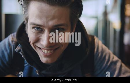 Close up photo of handsome Caucasian man looking and smiling at camera with happy cheerful expression Stock Photo