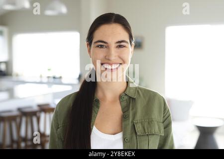 Portrait of smiling caucasian beautiful young woman dressed in jacket standing at home, copy space Stock Photo